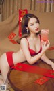 A woman in a red lingerie holding a red envelope.