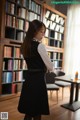 A woman standing in front of a bookshelf in a library.