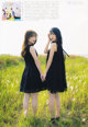 Two young women standing in a field of tall grass.