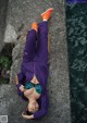 A woman laying on a rock by the water.