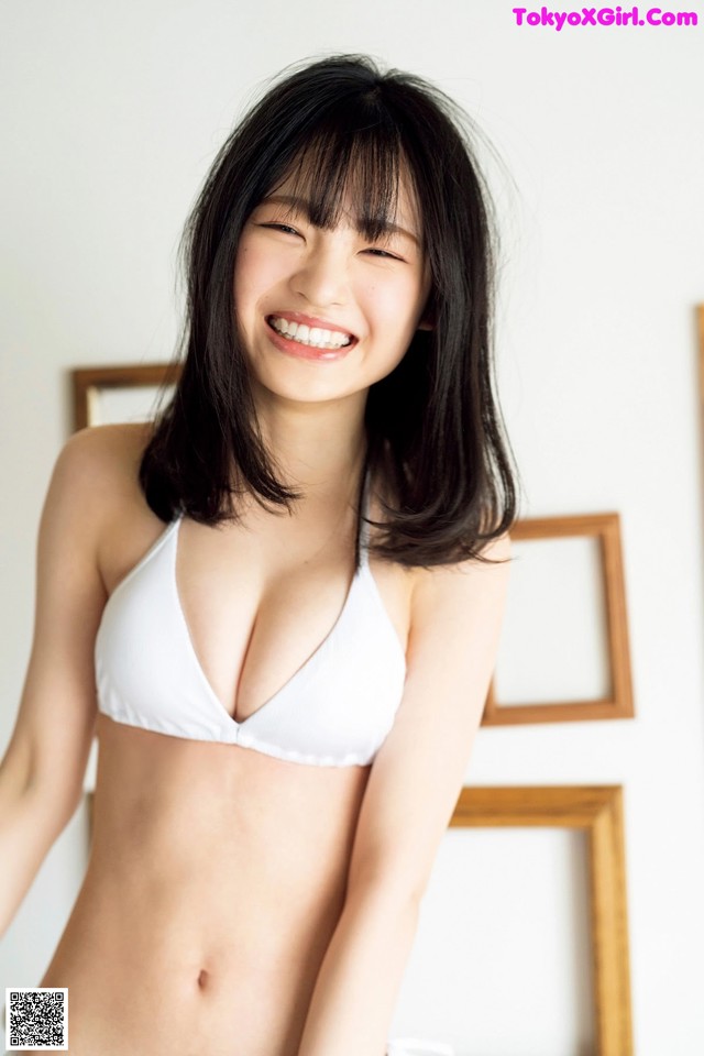 A woman in a white bikini posing for a picture.