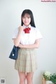 A woman in a school uniform posing for a picture.