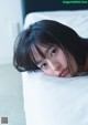 A little girl laying on top of a white pillow.